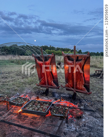 Traditional Argentinian asado, lamb and piglet slow-cooked over a wood fire and brushed with a spicy Traditional Argentinian asado, lamb and piglet slow-cooked over a wood fire and brushed with a spicy 119056659