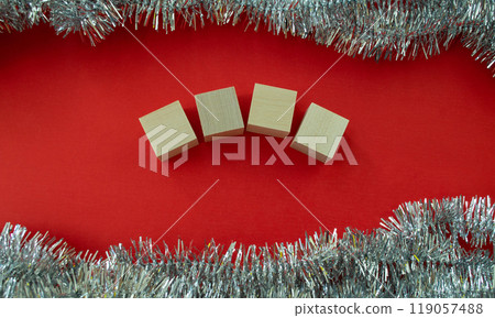 New Year's card template. Wooden cubes for the number of the year and tinsel on a red background. New Year's card template. Wooden cubes for the number of the year and tinsel on a red background. 119057488