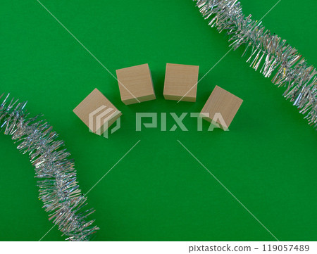New Year's card template. Wooden cubes of the year number, tinsel on a green background. New Year's card template. Wooden cubes of the year number, tinsel on a green background. 119057489