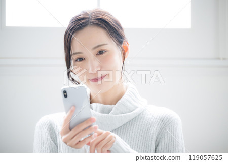 一位女士敲擊智慧型手機的特寫,冬季冰藍色 一位女士敲擊智慧型手機的特寫,冬季冰藍色 119057625