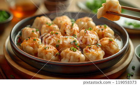 Steaming dumplings served in a bowl with chopsticks in a cozy kitchen. Generative AI Steaming dumplings served in a bowl with chopsticks in a cozy kitchen. Generative AI 119058373