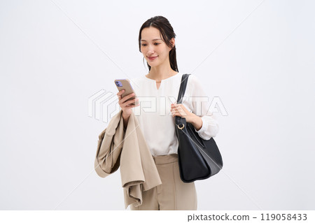 A businesswoman holds her jacket because it's hot 119058433