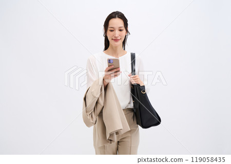 A businesswoman holds her jacket because it's hot 119058435