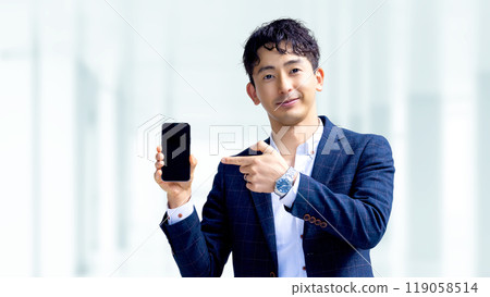 Male businessman pointing at smartphone to guide Male businessman pointing at smartphone to guide 119058514