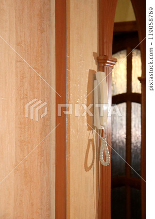 The intercom handset hangs in profile in the reflection of a mirror The intercom handset hangs in profile in the reflection of a mirror 119058769