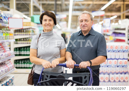 Married couple choose groceries together in supermarket 119060297