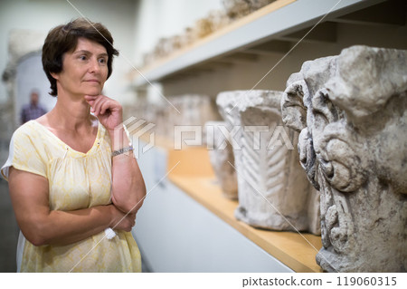 Woman examines the exhibit in historical museum 119060315