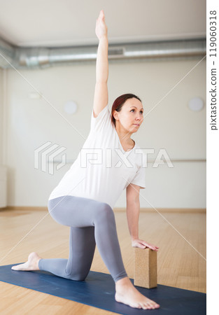Pregnant woman is engaged in yoga. Warrior Pose or Virabhadrasana 119060318