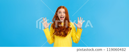 Excited, overwhelmed happy redhead cute girl in yellow sweater, screaming from joy telling about christmas gifts, showing ten fingers, order dozen products, standing joyful blue background Excited, overwhelmed happy redhead cute girl in yellow sweater, screaming from joy telling about christmas gifts, showing ten fingers, order dozen products, standing joyful blue background 119060482