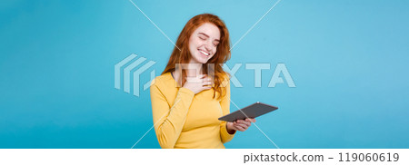 People and Technology Concept - Close up Portrait young beautiful attractive redhair girl happy smiling on digital table with wining something. Blue Pastel Background. Copy space 119060619