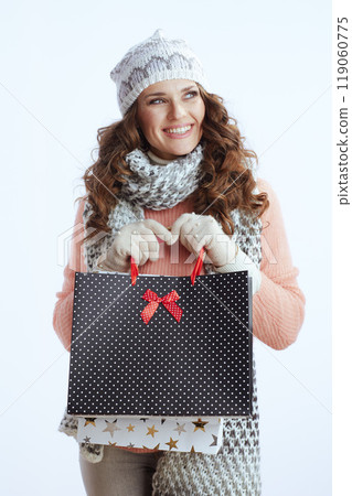 happy modern woman in sweater, mittens, hat and scarf on white 119060775