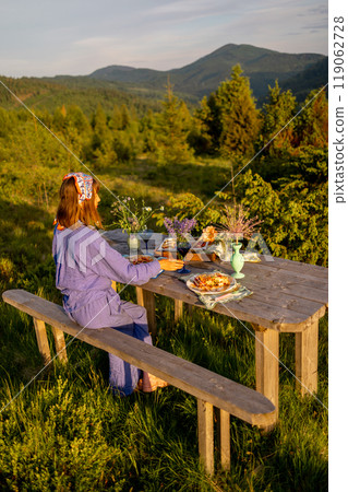 Woman decorates a table for dinner on nature Woman decorates a table for dinner on nature 119062728