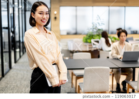 一個拿著電腦的商務人士微笑著看著這個 119063017