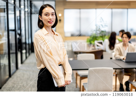 站立時雙手拿著筆記型電腦的商務人士 119063018