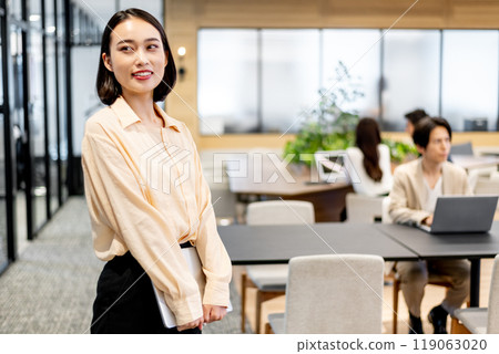 Business person standing and holding a laptop 119063020
