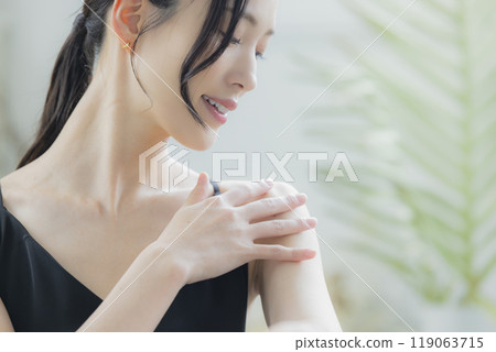 A woman in a black camisole dress standing by the window A woman in a black camisole dress standing by the window 119063715