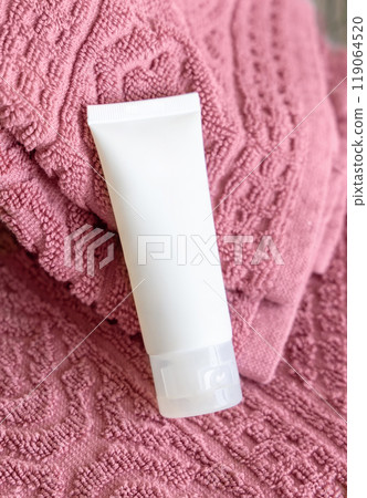 White blank squeeze tube on pink folded bath towels close up, cosmetic mockup White blank squeeze tube on pink folded bath towels close up, cosmetic mockup 119064520