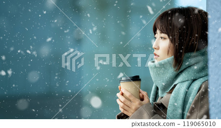 A woman drinking a hot drink on a snowy winter street corner A woman drinking a hot drink on a snowy winter street corner 119065010