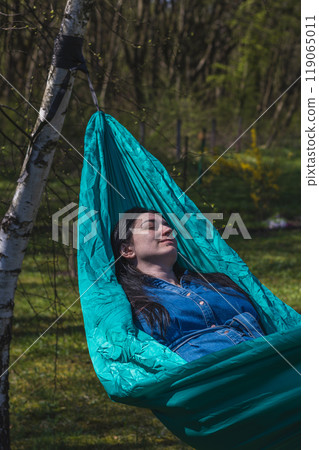 A woman relaxes in a hammock in the garden Lviv Ukraine 07.04.2024 A woman relaxes in a hammock in the garden Lviv Ukraine 07.04.2024 119065011