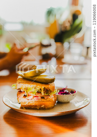 Cheese sandwich with pickles on a plate in cafe. Cheese sandwich with pickles on a plate in cafe. 119066008