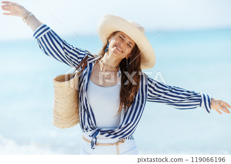 happy modern woman on ocean shore rejoicing 119066196