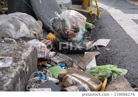 Littered street corner with garbage bags and debris Littered street corner with garbage bags and debris 119066276