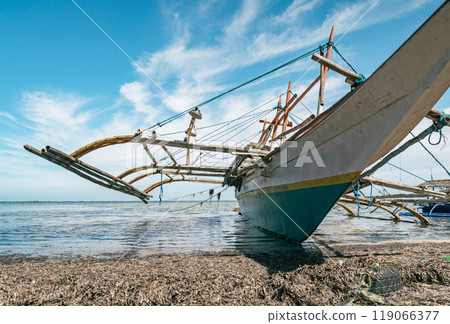 Beached wooden boat on sandy shore with tires Beached wooden boat on sandy shore with tires 119066377