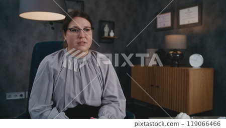 Female therapist sits in chair, talks to African American adult man, provides therapy 119066466