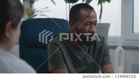 Depressed African American military man with PTSD shares feelings with psychologist Depressed African American military man with PTSD shares feelings with psychologist 119066528