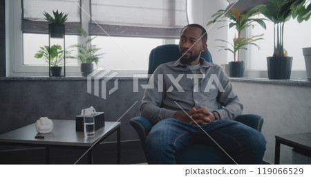 African American adult man talks to female therapist, discuses psychological trauma on therapy African American adult man talks to female therapist, discuses psychological trauma on therapy 119066529