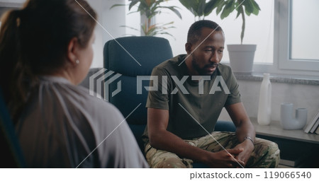 Back view of female psychologist providing therapy session to soldier 119066540