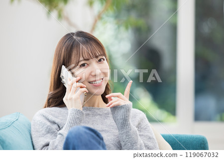 坐在沙發上打電話的女人 119067032