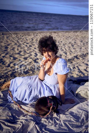 young plus size woman eating carrots with her pet rabbit by the sea in copenhagen 119067151
