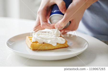 Girl Adding A Topping Whipped Cream On A Belgium Waffle 119067265