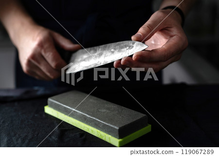 Head Chef Inspects Sharpened Kitchen Knife Closely Head Chef Inspects Sharpened Kitchen Knife Closely 119067289