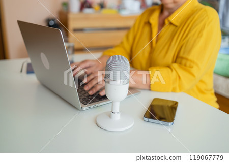 Female podcaster use smartphone and speaking with audience on microphone to recording video podcast. Female podcaster use smartphone and speaking with audience on microphone to recording video podcast. 119067779