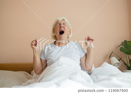Portrait of beauty Caucasian 50s 60s woman awaking, wake up on the bed. Young beautiful female stretching her arms in fresh early morning, relax peaceful morning routine yawn concept banner Portrait of beauty Caucasian 50s 60s woman awaking, wake up on the bed. Young beautiful female stretching her arms in fresh early morning, relax peaceful morning routine yawn concept banner 119067800