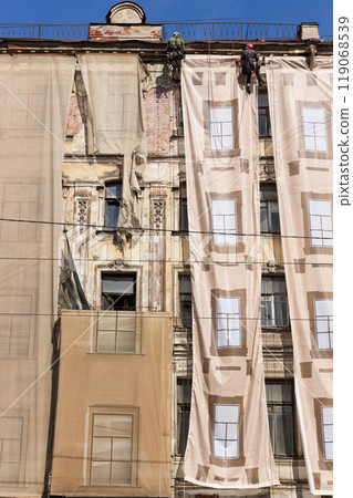 Repair work of the facade of an old building at an altitude 119068539