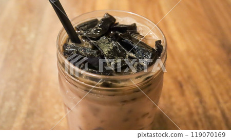 Ice milk cincau is a traditional cold beverage from Indonesia or iced grass jelly with milk and brown sugar. Ice milk cincau is a traditional cold beverage from Indonesia or iced grass jelly with milk and brown sugar. 119070169