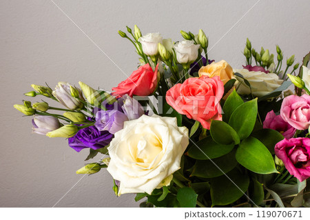 Celebrate special occasions with a colorful summer bouquet featuring fresh roses, eucalyptus, and eustoma blooms, creating an elegant and fragrant floral arrangement 119070671