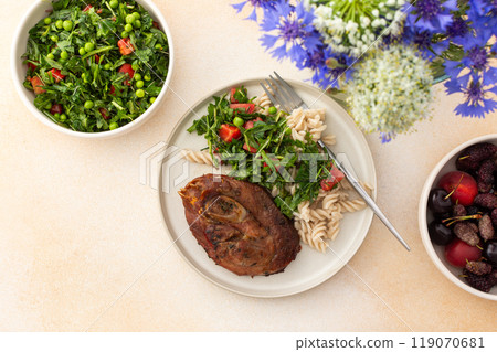 This delicious meal features savory turkey with gluten-free pasta, a vibrant salad of fresh vegetables and herbs, and ripe fruits, offering a nutritious and satisfying option for breakfast or lunch 119070681