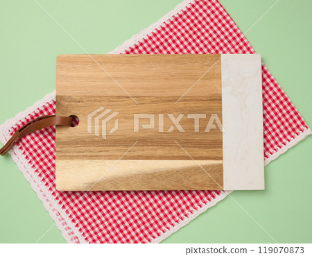 Empty rectangular wooden kitchen cutting board on green background 119070873