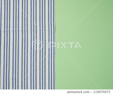 Blue  linen striped kitchen towel on a green background, top view Blue  linen striped kitchen towel on a green background, top view 119070875