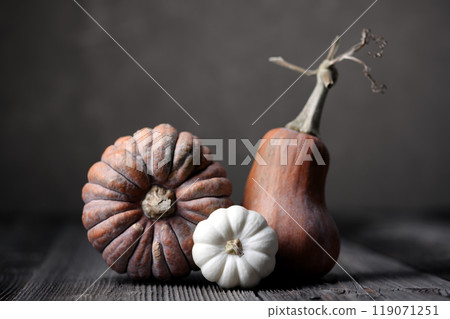 Three different pumpkins on wooden table Three different pumpkins on wooden table 119071251