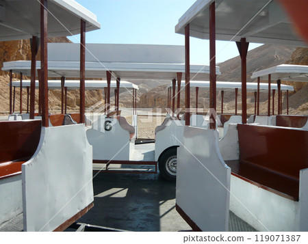 White tourist cars for transporting people to places of interest on the background of the desert White tourist cars for transporting people to places of interest on the background of the desert 119071387