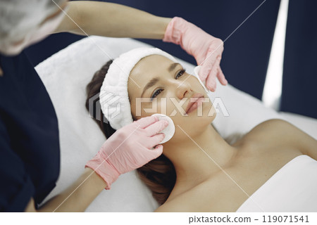 Cosmetologist treats client's skin. Woman with cosmetologist. Lady in a beauty studio. 119071541