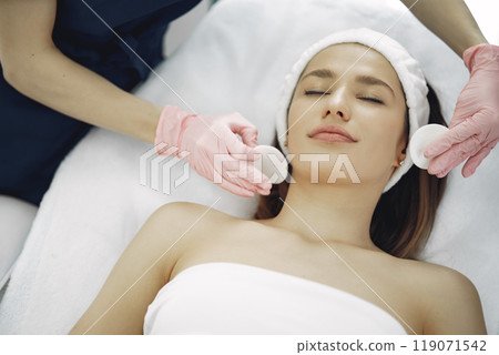 Cosmetologist treats client's skin. Woman with cosmetologist. Lady in a beauty studio. 119071542