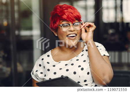 Young African American female working in an office. Lady in a white blouse. 119071550