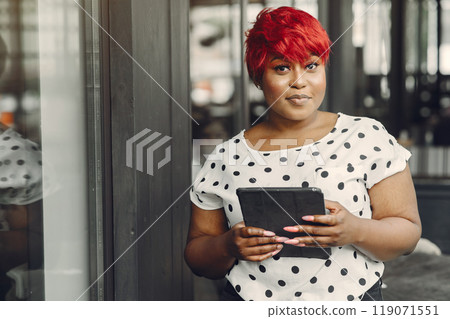 Young African American female working in an office. Lady in a white blouse. 119071551