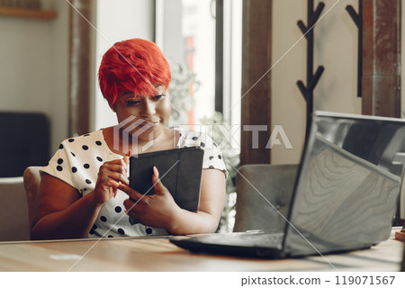 Young African American female working in an office. Lady in a white blouse. 119071567